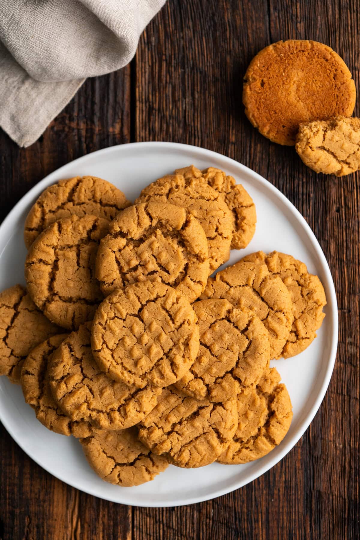 Peanut butter cookies stacked on a white plate.