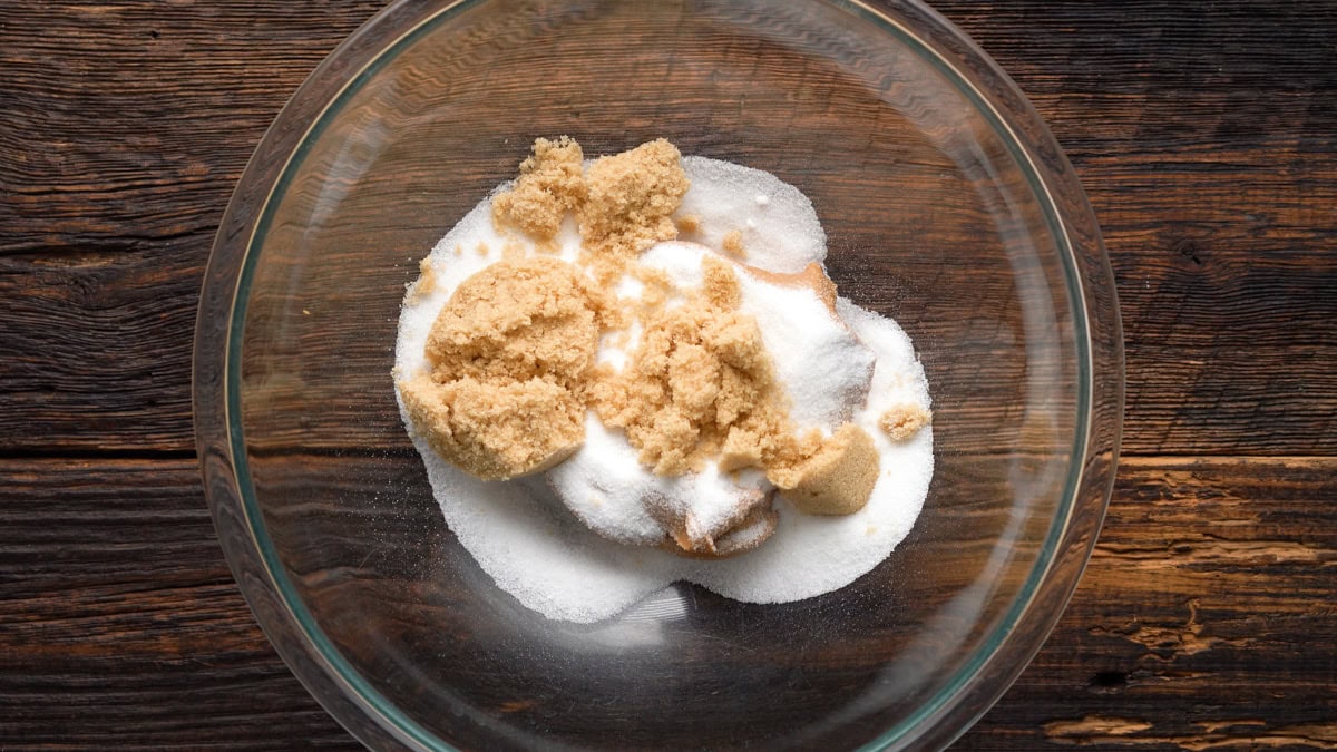 Peanut butter and sugars added into a glass bowl.