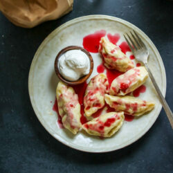 Cherry dumplings and a fork on a plate.