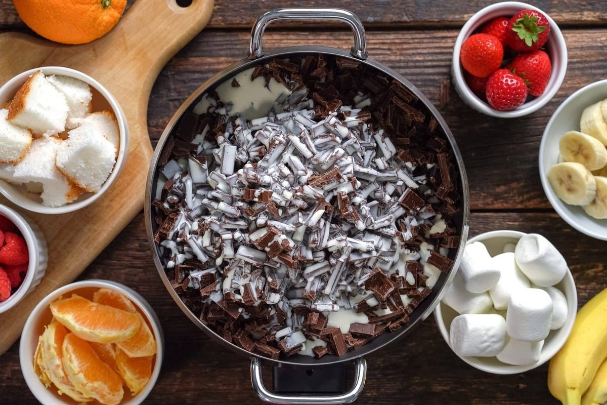Grated chocolate with heavy cream on an electric fondue pot.