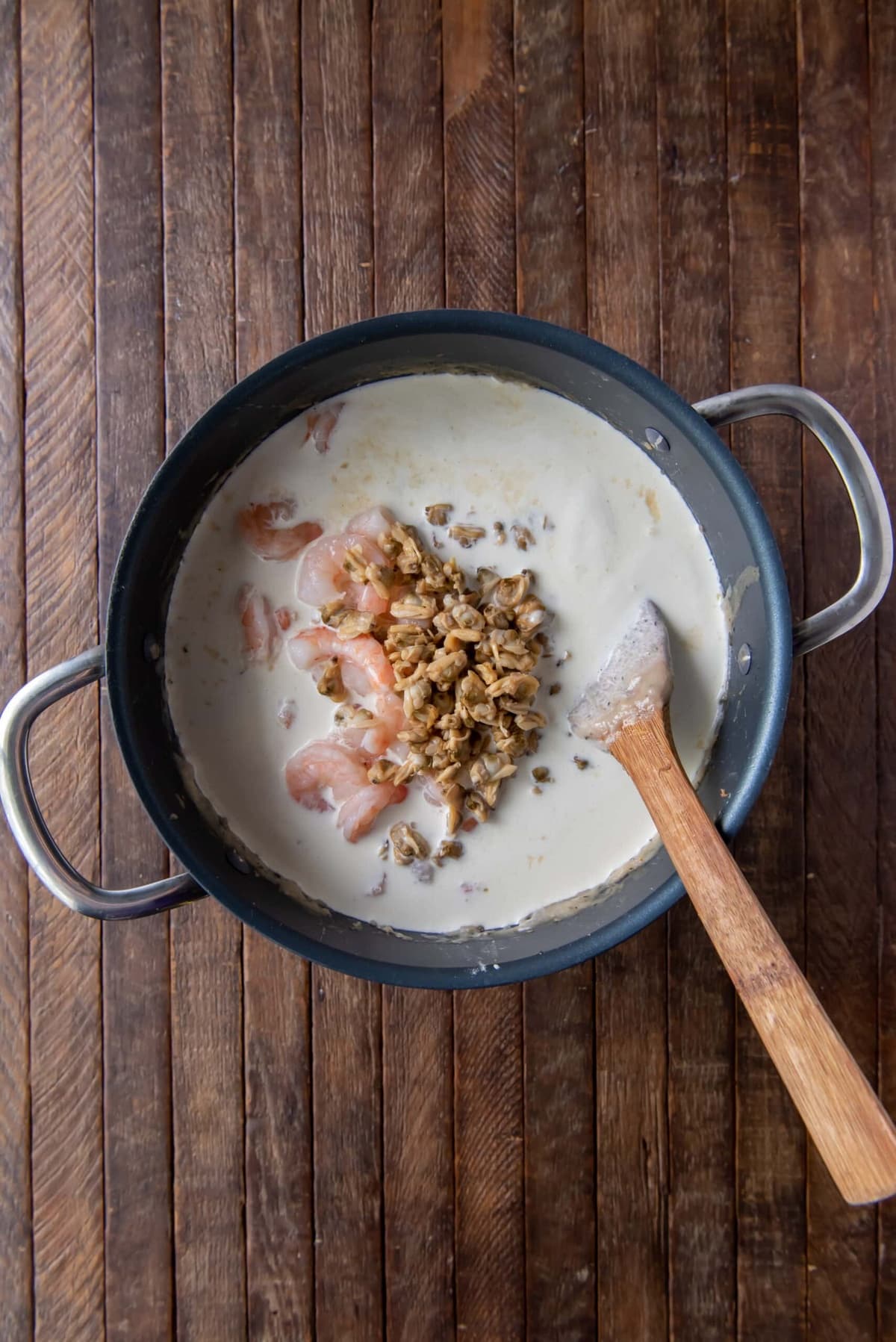 A pot of creamy seafood chowder with shrimp and clam meat.