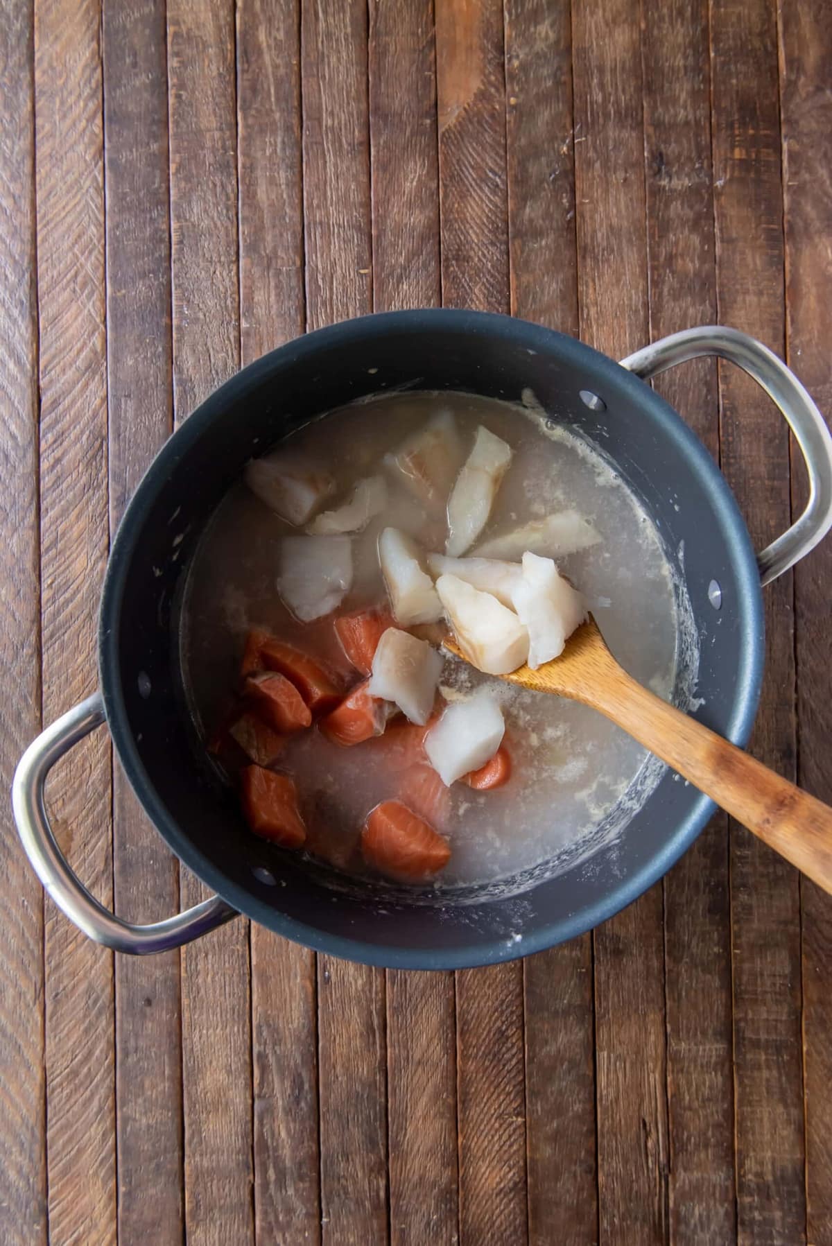 Pot with fish base and chunks of salmon and halibut.