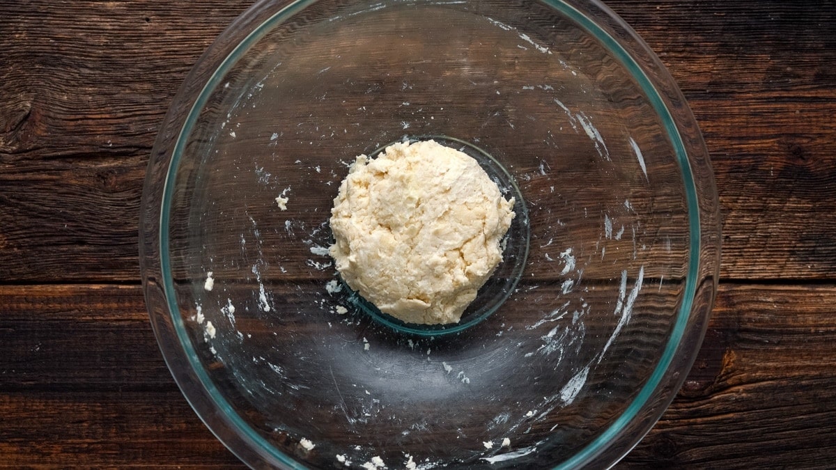 Kneading the flour and sour cream into a ball of dough.