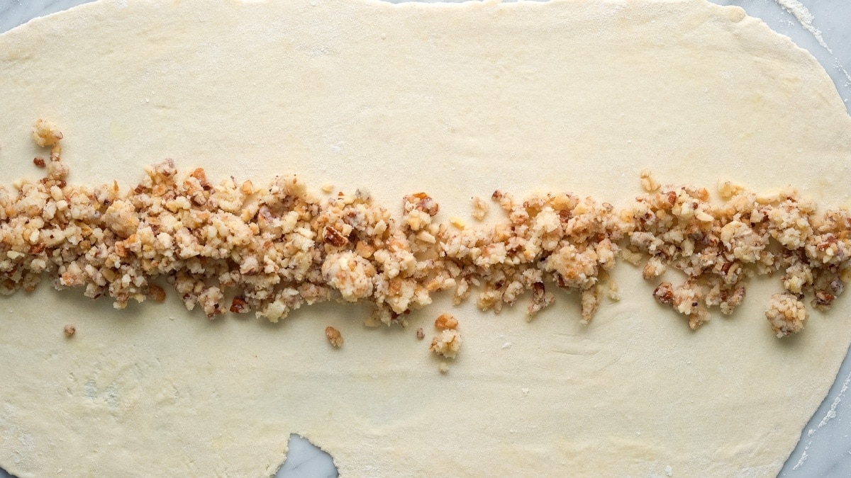 Spreading the filling evenly over the middle of the rolled-out dough.
