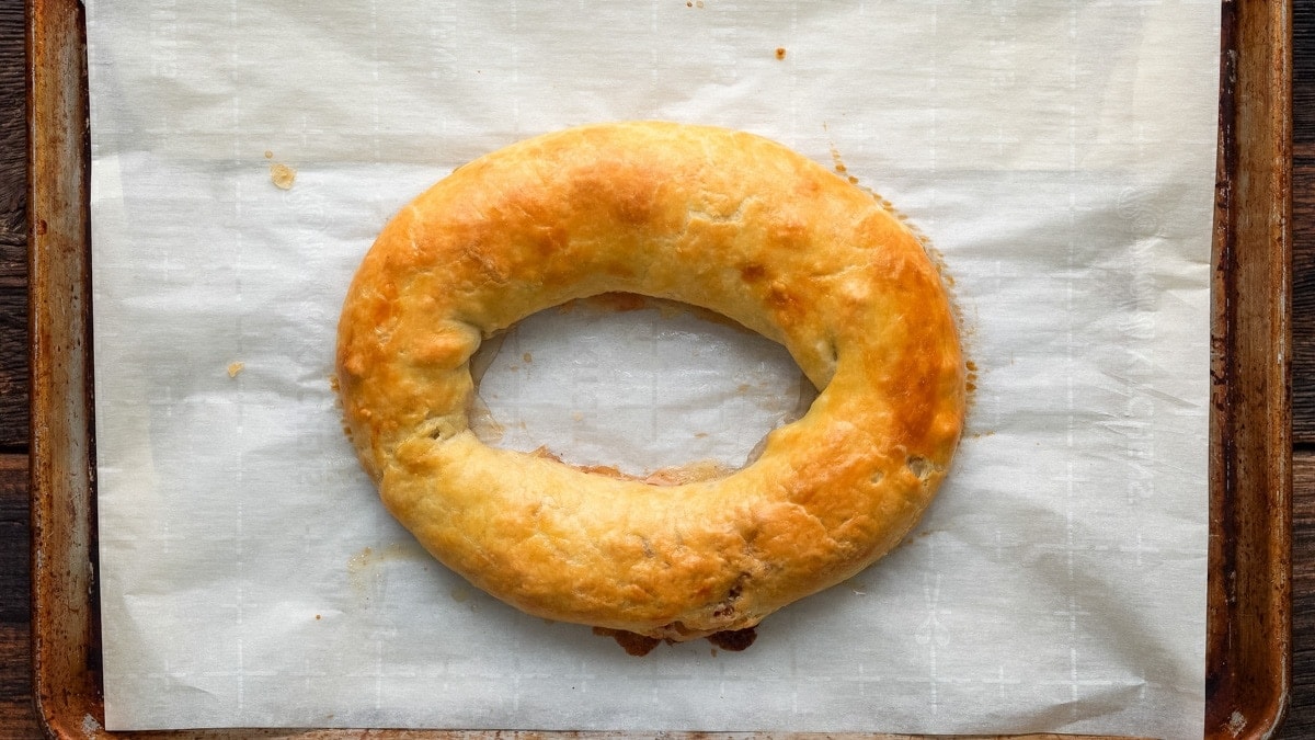 Baked Danish Kringle laying on a parchment paper.