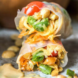 Close-up view of fresh Thai spring rolls with peanut sauce.