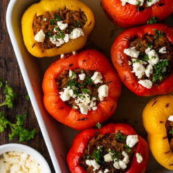 These Greek Stuffed Peppers are vibrant and packed with ground meat, rice, chickpeas, and all of your favorite Mediterranean flavors!