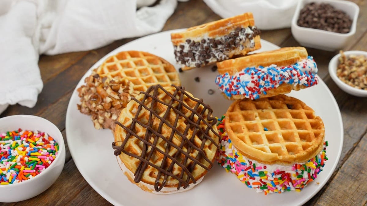 Homemade waffle ice cream sandwiches on a white plate.