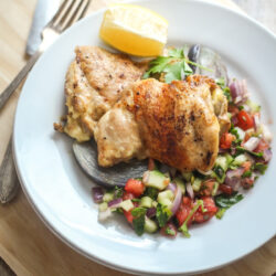 A plate with Israeli chicken, served with Jerusalem salad.
