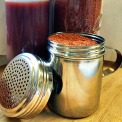 A shaker and jar filled with dry rib rub.