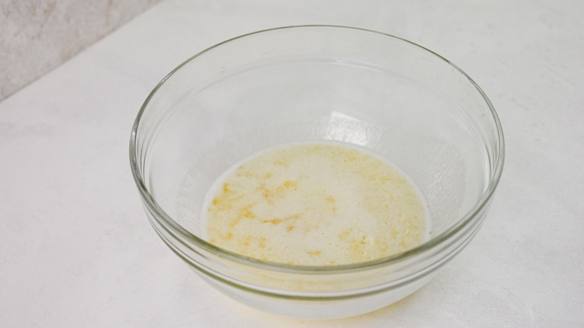 Melted butter, sugar, lemon juice and zest, almond flavor, and vanilla extract in a large mixing bowl.
