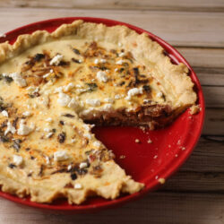 Mediterranean quiche on a red pie dish.