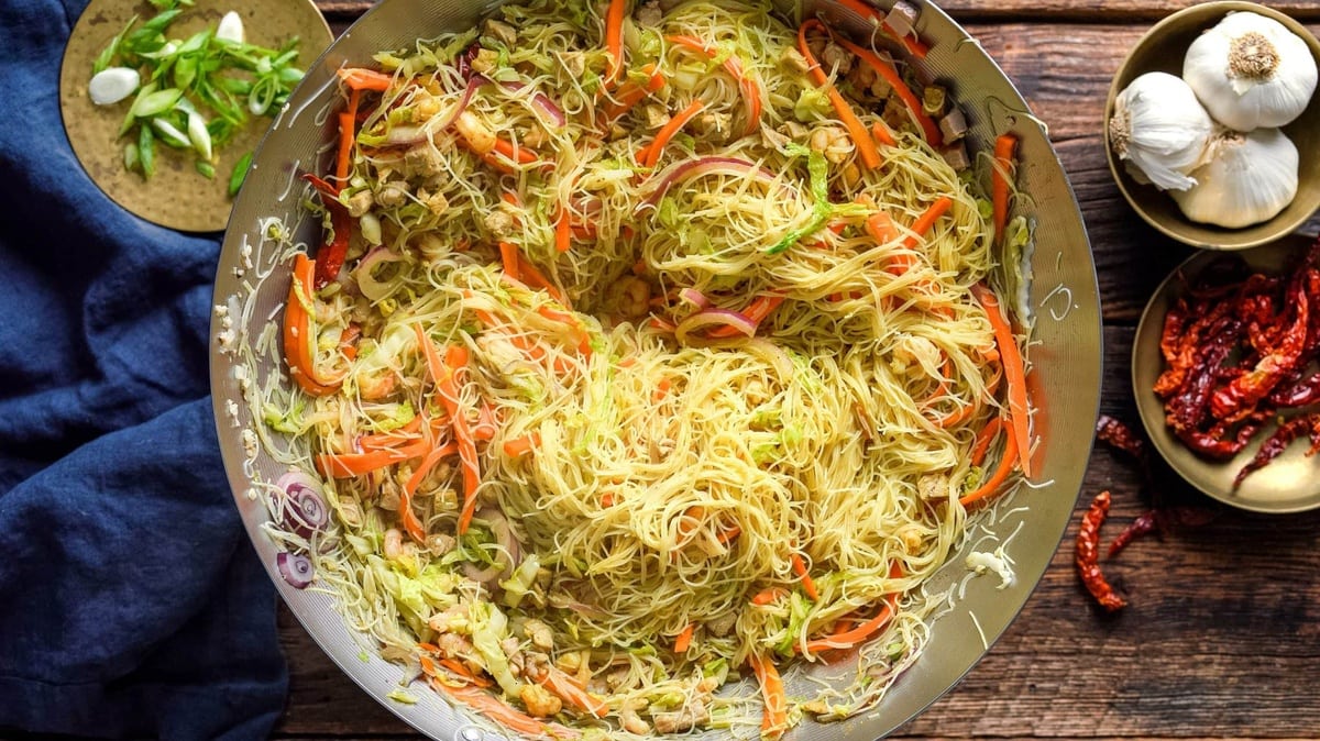 Curry coloring our noodles in the wok.
