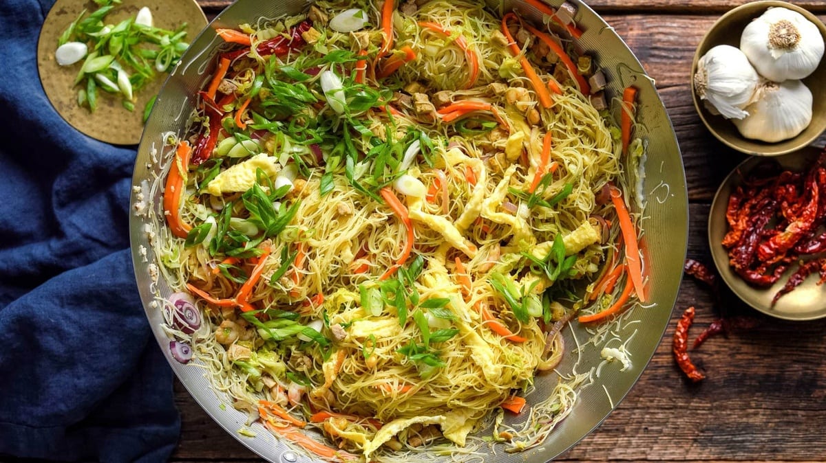 Noodles in a wok on a table.