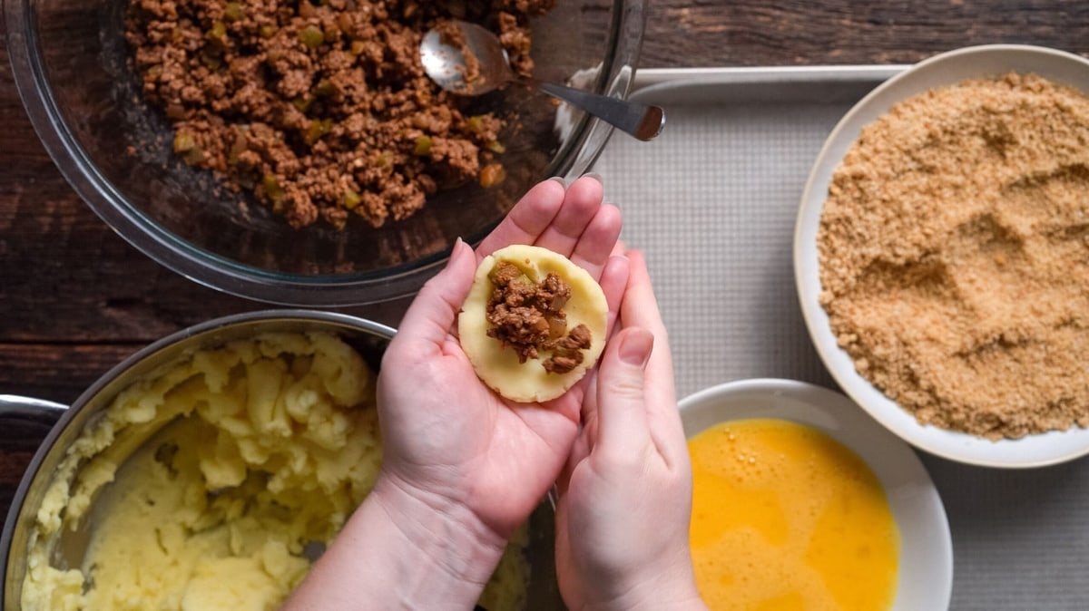 Beef mixture into the middle of the potato ball.