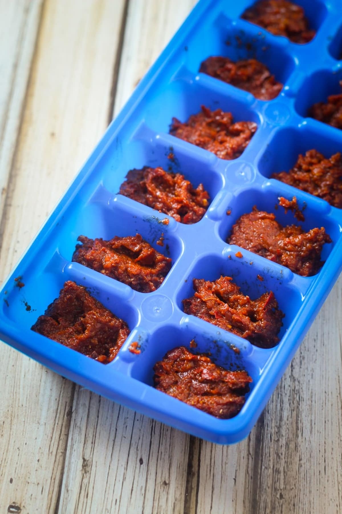 Red curry paste in an ice cube tray.