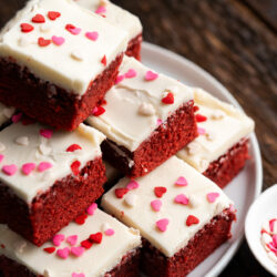 Indulge in a batch of these homemade Red Velvet Brownies. A moist brownie topped with a creamy frosting to create a delicious and colorful treat!