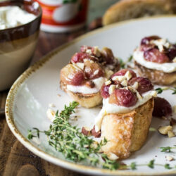 A serving plate with several roasted grape Crostinis.