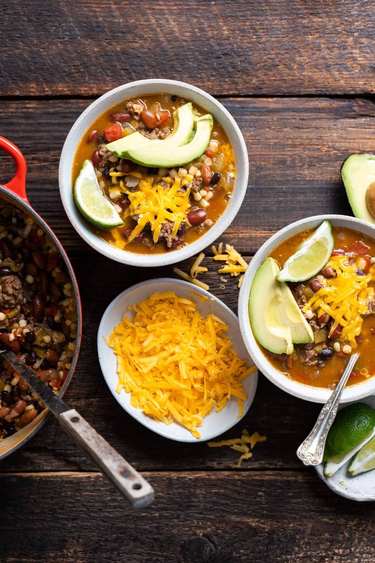 Two bowls of Santa Fe Soup, garnished with a slice of avocado and a wedge of lime.