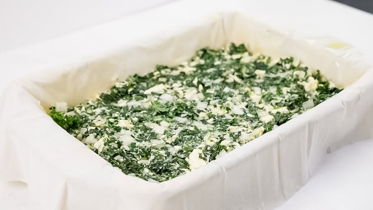 Spreading the spinach mixture over the dough evenly.