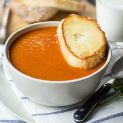 Sun Dried tomato soup in a bowl served with crusty bread.
